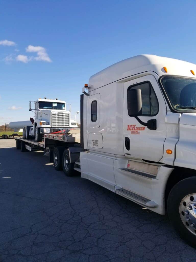 Semi truck on step deck trailer for transport