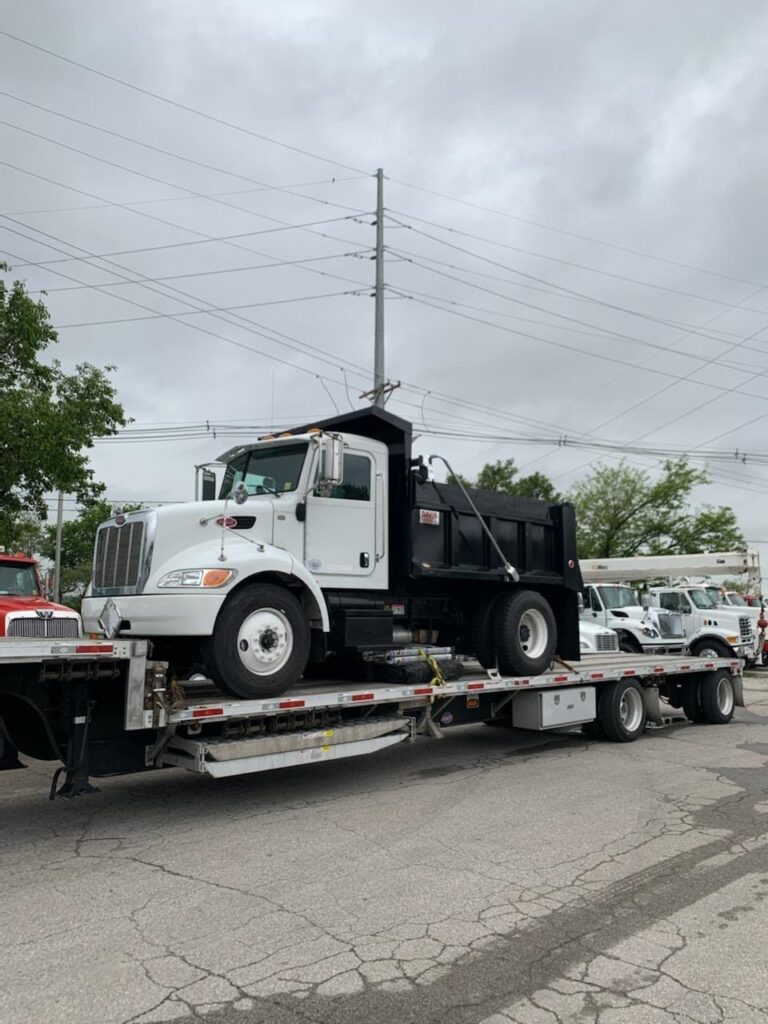 Single axle dump truck on step deck
