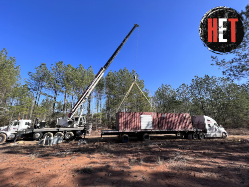 Container being loaded on trailer for transport.