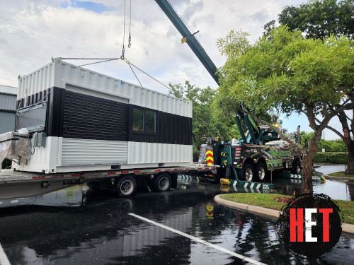 Container being loaded onto trailer for transport.