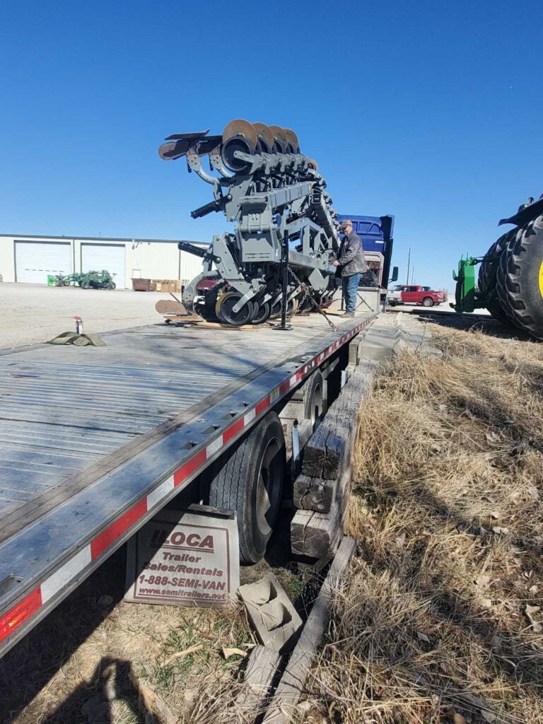 Cultivator on step deck trailer