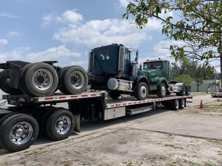 Semi trucks loaded on step deck trailer