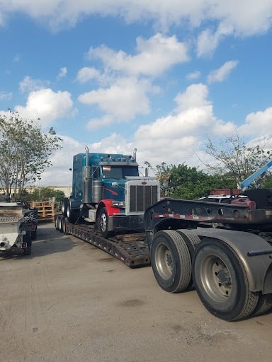 Semi truck on RGN trailer for transport