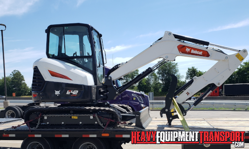 Bobcat mini skid steer transported on a trailer.