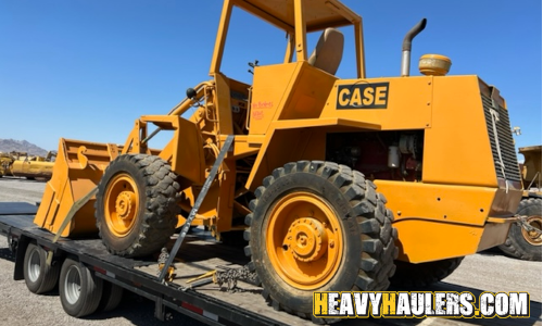 CASE wheel loader transported on a trailer.
