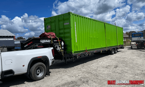Green container transported by a pickup truck.