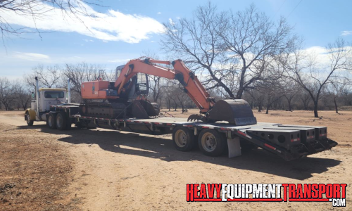 Hitachi excavator transported on a trailer.