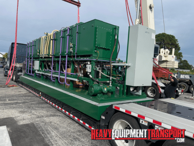 Hydraulic power unit being loaded on to a lowboy trailer for transport