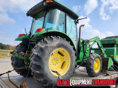 Hauling a 2013 John Deere 6105D tractor with a front loader.