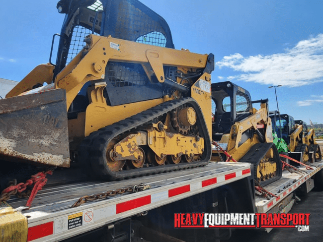skid steers on trailer for transport